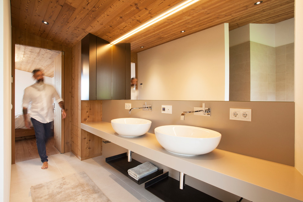 Photo of a medium sized rustic bathroom in Munich with beige cabinets, beige walls, ceramic flooring, a vessel sink and solid surface worktops.