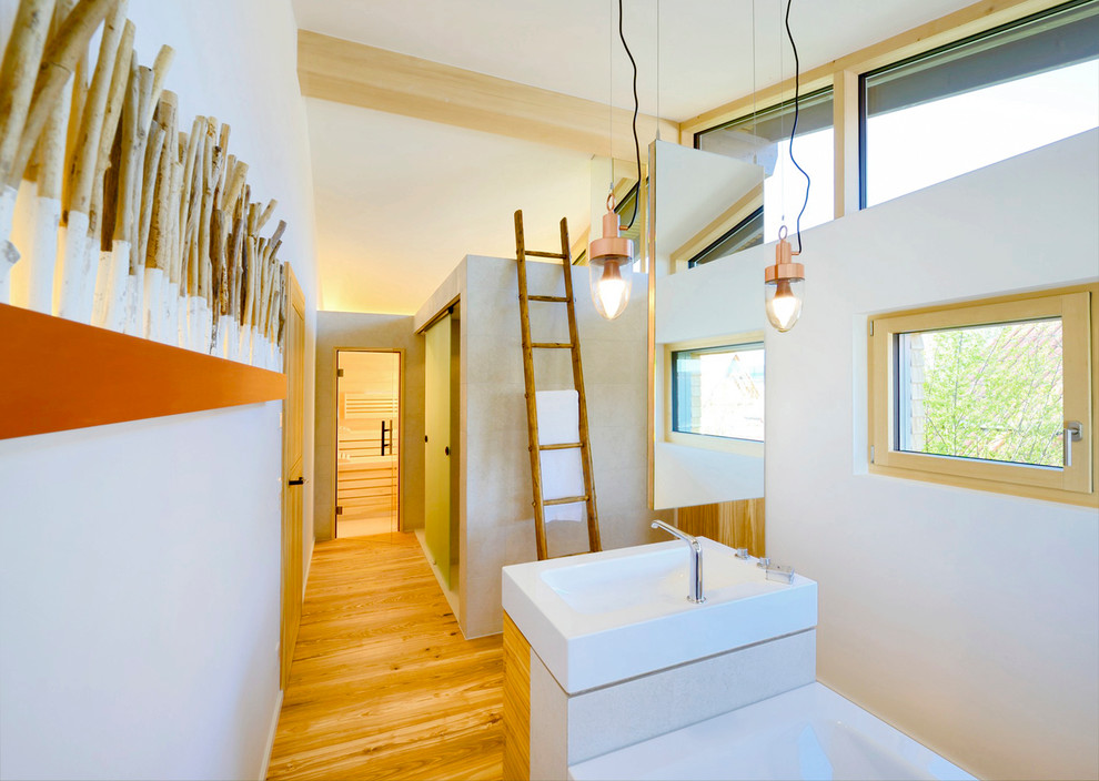 Nordisches Badezimmer En Suite mit Aufsatzwaschbecken, weißer Wandfarbe und braunem Holzboden in Sonstige