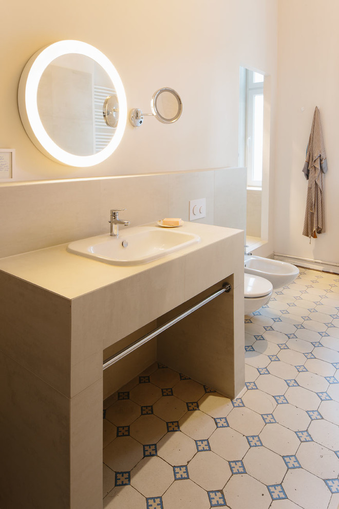 Идея дизайна: ванная комната среднего размера в классическом стиле с белыми стенами, полом из керамической плитки, биде, бежевой плиткой, накладной раковиной и зеркалом с подсветкой