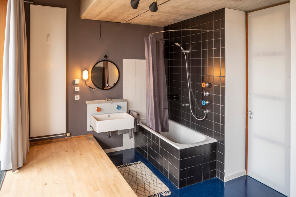 Diseño de cuarto de baño principal y único actual pequeño con bañera encastrada, combinación de ducha y bañera, baldosas y/o azulejos negros, lavabo tipo consola, suelo azul y ducha con cortina