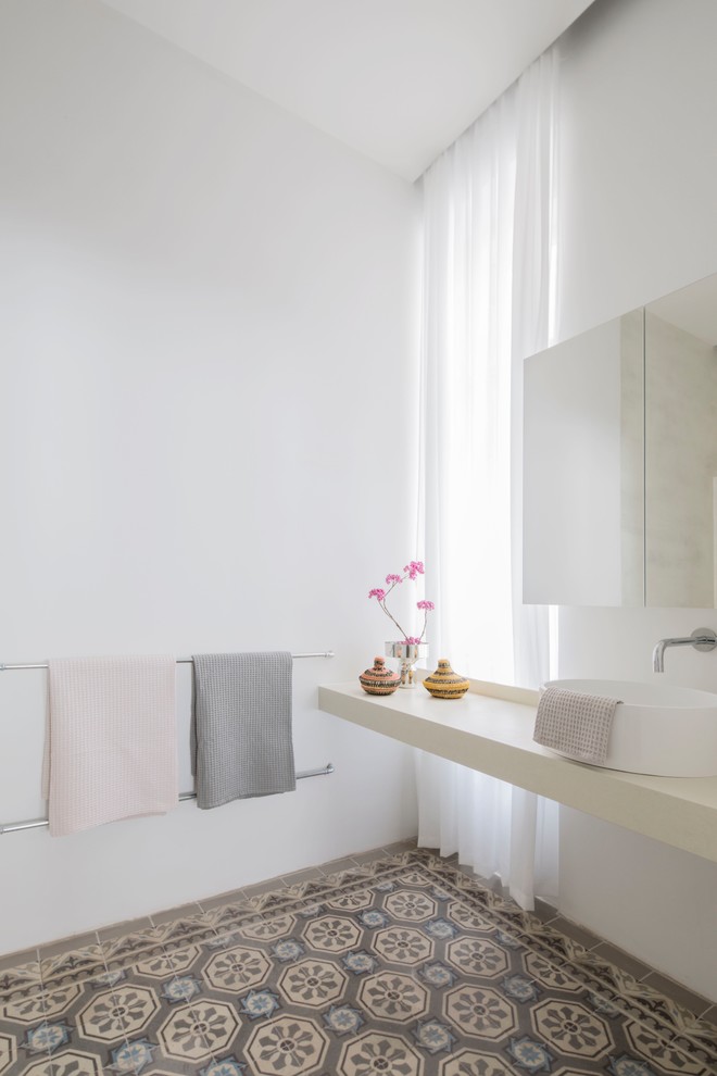 Foto de cuarto de baño moderno con paredes blancas, suelo de azulejos de cemento, lavabo sobreencimera y suelo multicolor