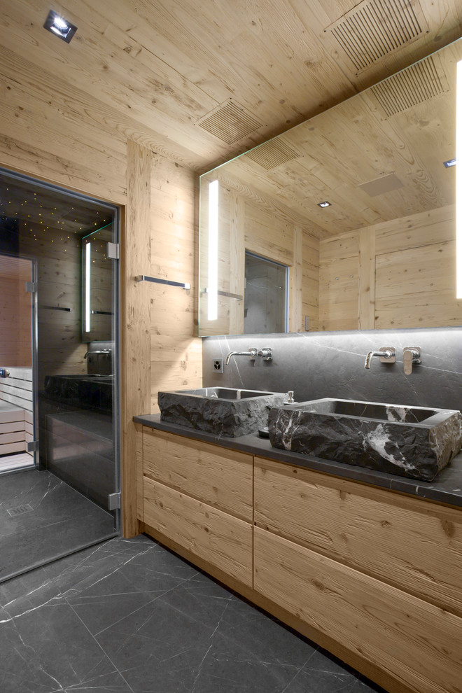 Rustik inredning av ett en-suite badrum, med skåp i ljust trä, ett fristående handfat och grått golv