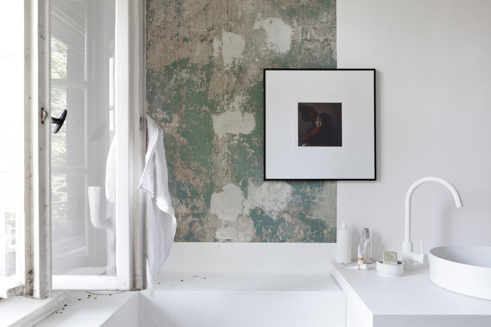 Nordisk inredning av ett litet vit vitt badrum med dusch, med öppna hyllor, ett platsbyggt badkar, en dusch/badkar-kombination, en vägghängd toalettstol, vit kakel, kakelplattor, vita väggar, mellanmörkt trägolv, ett fristående handfat, träbänkskiva, dusch med duschdraperi och grått golv