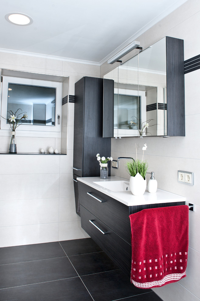Exempel på ett mellanstort modernt badrum, med släta luckor, svarta skåp, svart kakel, vit kakel, vita väggar, ett integrerad handfat och träbänkskiva