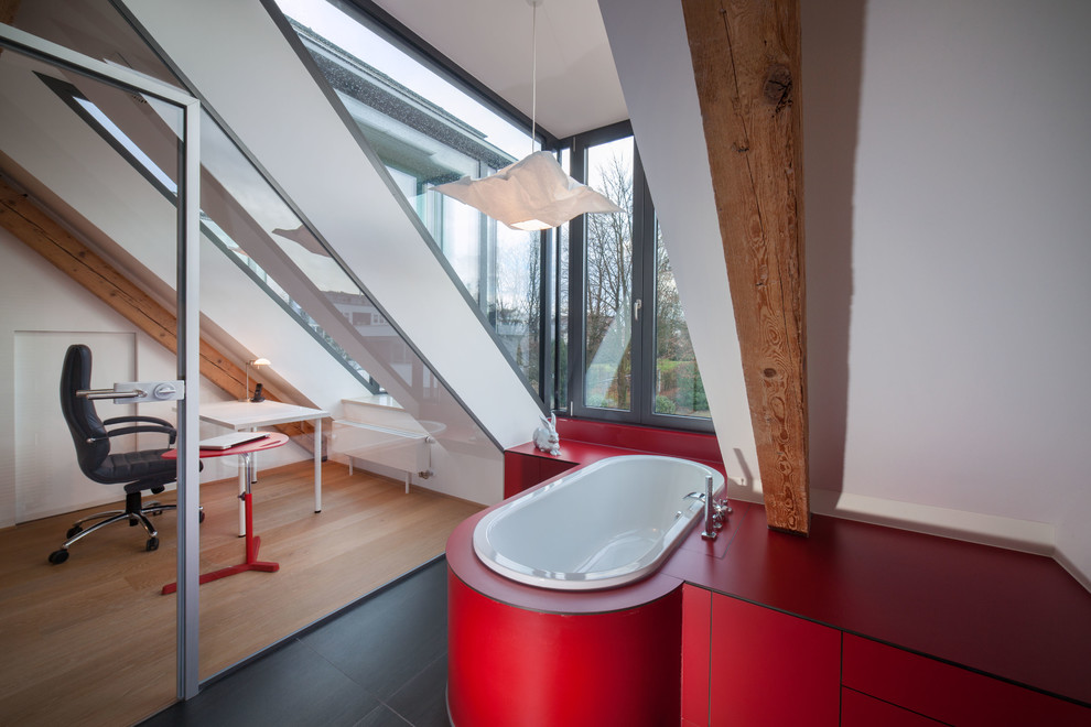 Kleines Modernes Badezimmer En Suite mit flächenbündigen Schrankfronten, roten Schränken, Einbaubadewanne, weißer Wandfarbe und schwarzem Boden in München