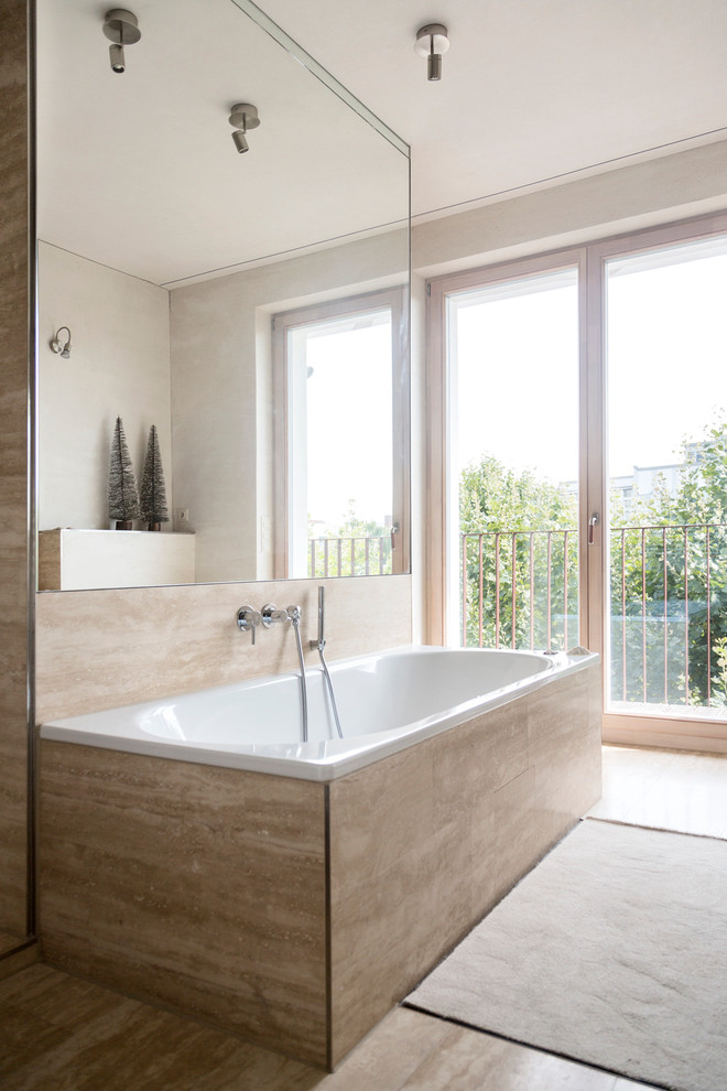 Idee per una stanza da bagno minimal di medie dimensioni con vasca da incasso, piastrelle beige e pareti beige