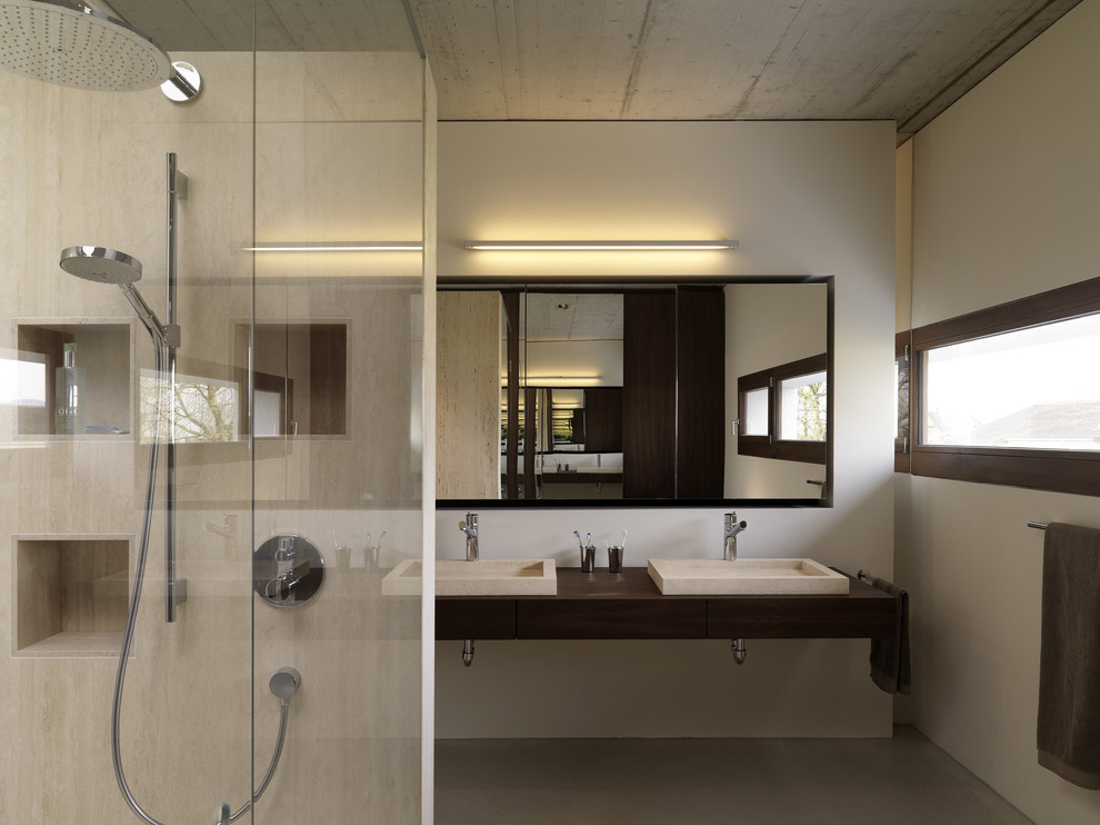 Cette photo montre une grande salle de bain tendance avec un carrelage beige, des dalles de pierre, un mur blanc, un lavabo posé et un plan de toilette en bois.