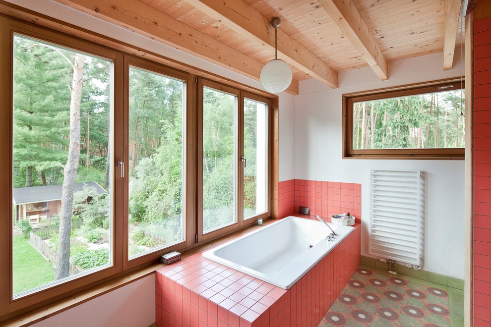Esempio di una stanza da bagno nordica di medie dimensioni con vasca da incasso, piastrelle rosse, piastrelle in ceramica, pareti bianche, pavimento con piastrelle in ceramica, pavimento verde e soffitto in legno