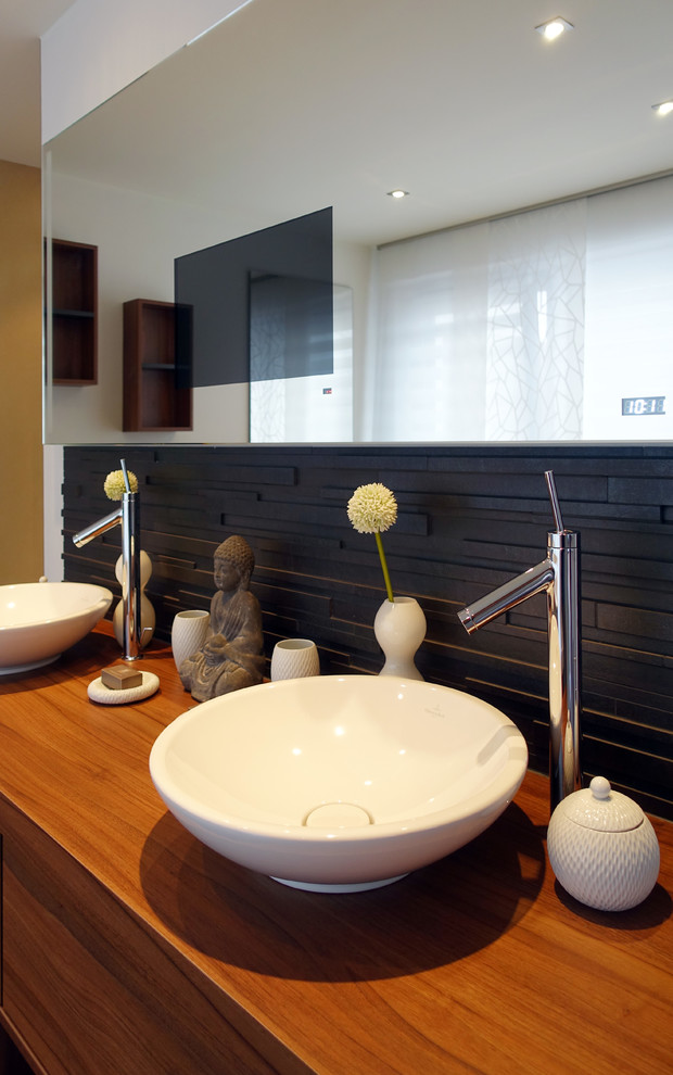 Mittelgroßes Modernes Badezimmer mit dunklen Holzschränken, freistehender Badewanne, bodengleicher Dusche, grauen Fliesen, weißer Wandfarbe, Keramikboden, Aufsatzwaschbecken und grauem Boden in Sonstige