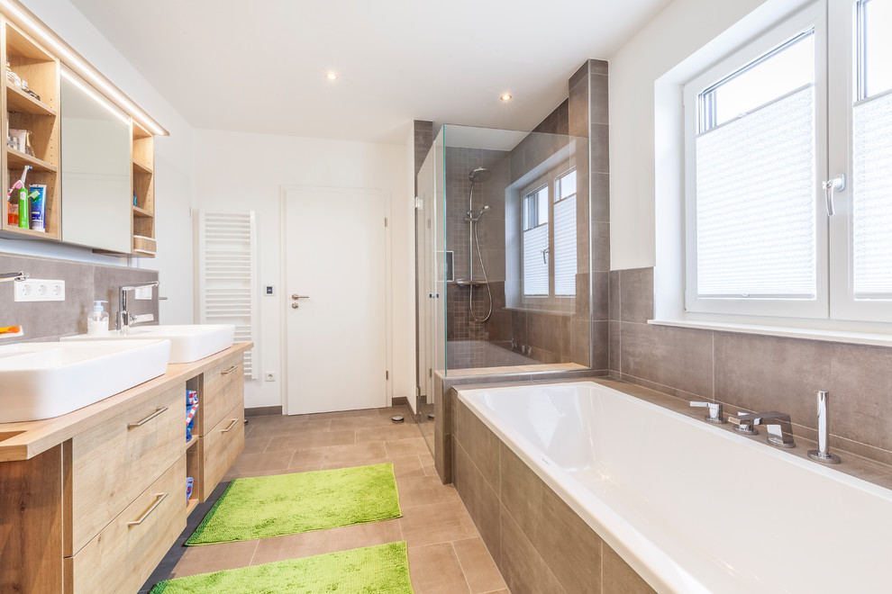 Large contemporary shower room bathroom in Other with recessed-panel cabinets, medium wood cabinets, a built-in bath, a built-in shower, brown tiles, cement tiles, white walls, cement flooring, a vessel sink, wooden worktops, brown floors, a hinged door and brown worktops.