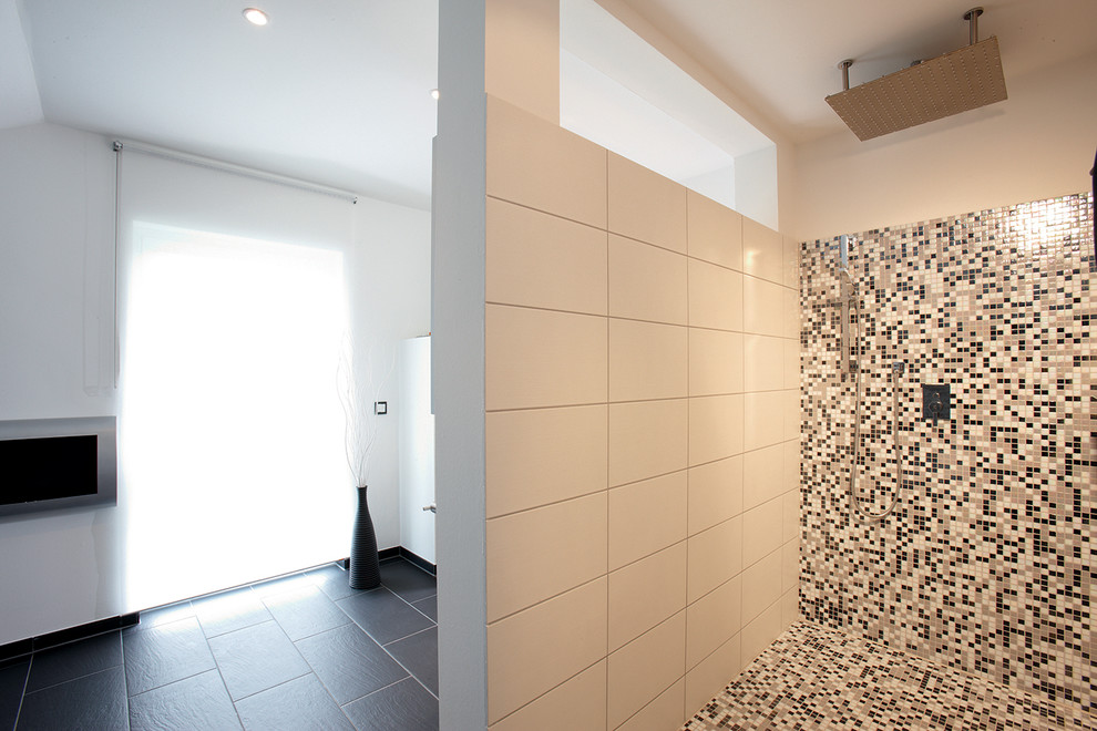 Modern inredning av ett vit vitt badrum, med svarta skåp, ett platsbyggt badkar, en kantlös dusch, grå kakel, stenhäll, vita väggar, ett nedsänkt handfat, svart golv och med dusch som är öppen