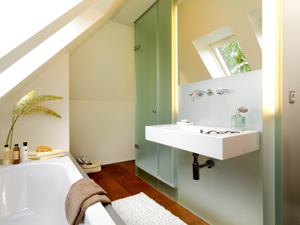 Réalisation d'une petite salle de bain principale design en bois brun avec un placard à porte plane, une baignoire posée, une douche d'angle, WC suspendus, un mur blanc, un sol en bois brun et un lavabo suspendu.