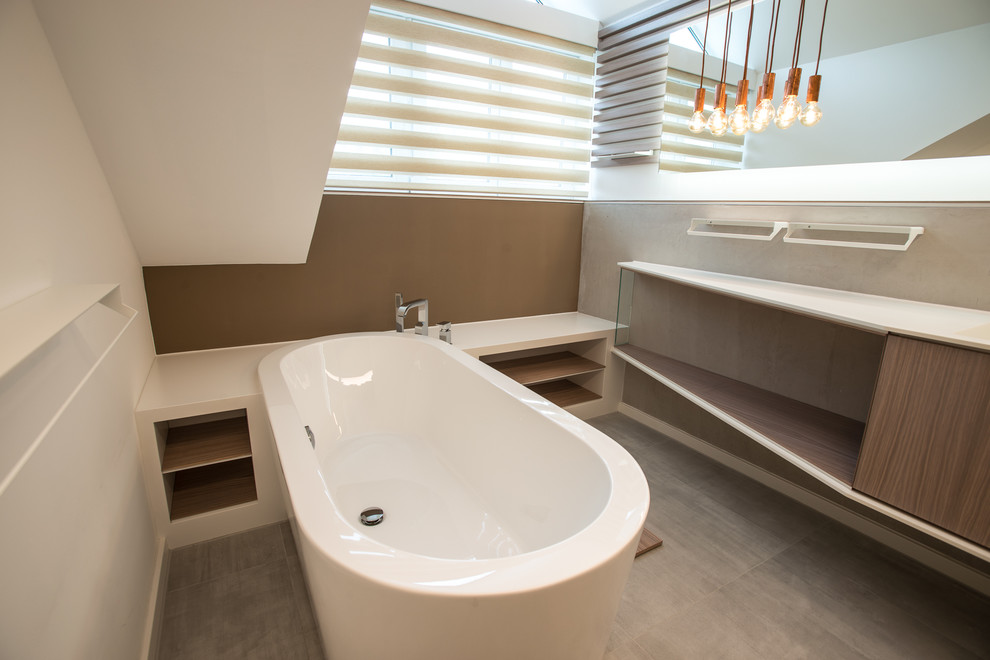 Mittelgroßes Modernes Badezimmer mit dunklen Holzschränken, Einbaubadewanne, grauen Fliesen, Steinfliesen und brauner Wandfarbe in Stuttgart
