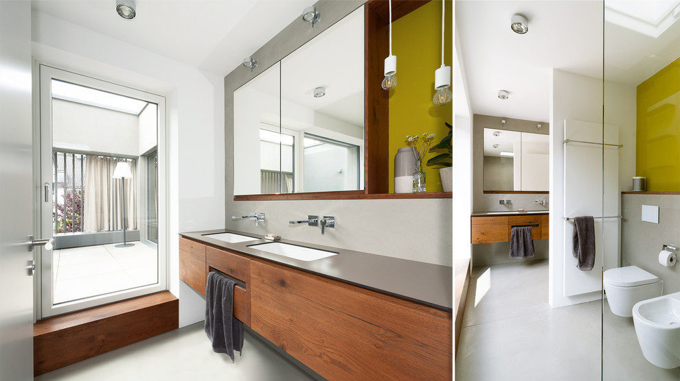 Foto de cuarto de baño principal actual grande con armarios con paneles lisos, puertas de armario de madera en tonos medios y encimeras grises