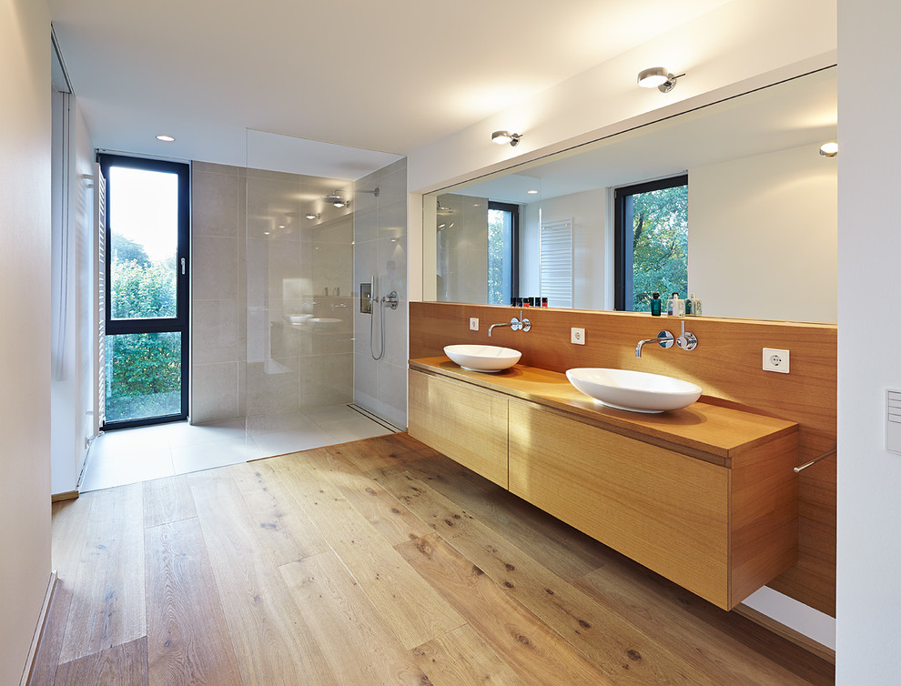 Idéer för att renovera ett stort funkis badrum med dusch, med skåp i mellenmörkt trä, en öppen dusch, vita väggar, mellanmörkt trägolv och ett fristående handfat