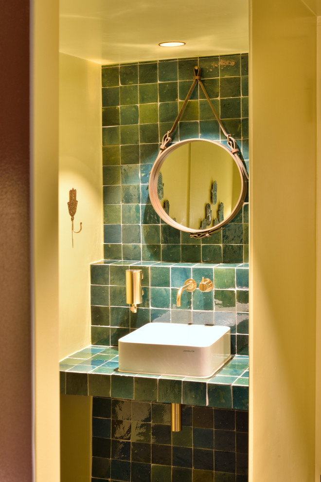 Modernes Badezimmer mit farbigen Fliesen, Keramikfliesen, gelber Wandfarbe, Aufsatzwaschbecken und türkiser Waschtischplatte in Sonstige