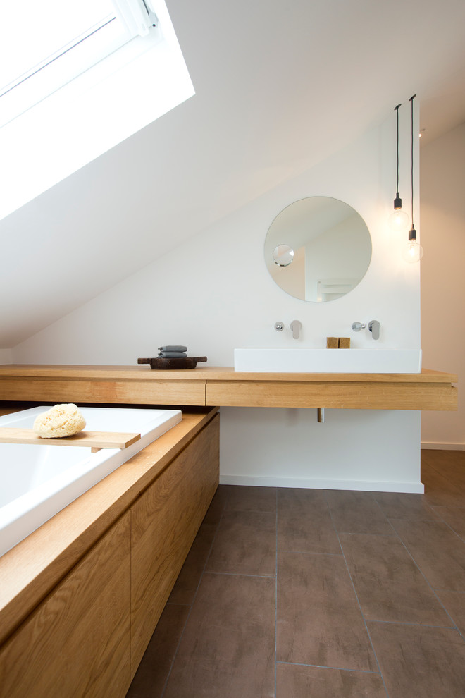 Inspiration för mellanstora moderna badrum, med släta luckor, skåp i ljust trä, ett platsbyggt badkar, en dusch i en alkov, en toalettstol med separat cisternkåpa, vita väggar, ett fristående handfat och träbänkskiva