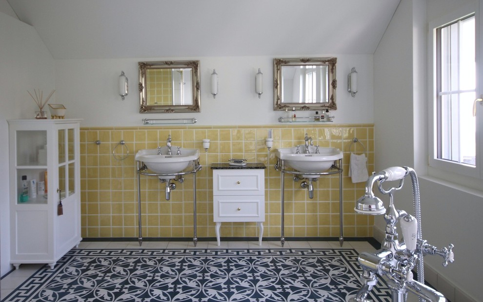 ミュンヘンにある広いカントリー風のおしゃれなマスターバスルーム (インセット扉のキャビネット、白いキャビネット、置き型浴槽、コーナー設置型シャワー、一体型トイレ	、黄色いタイル、セラミックタイル、白い壁、セメントタイルの床、コンソール型シンク、青い床、開き戸のシャワー) の写真
