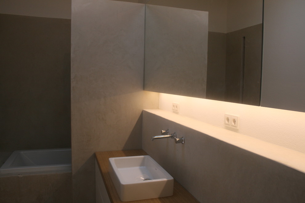 Esempio di una stanza da bagno con doccia minimal di medie dimensioni con vasca da incasso, WC a due pezzi, lavabo a bacinella e top in legno