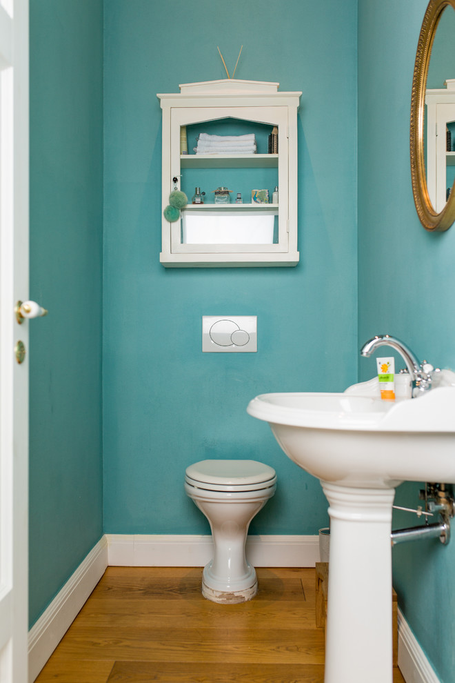 Kleines Modernes Badezimmer mit Kassettenfronten, weißen Schränken, Löwenfuß-Badewanne, blauer Wandfarbe, hellem Holzboden und braunem Boden in Sonstige