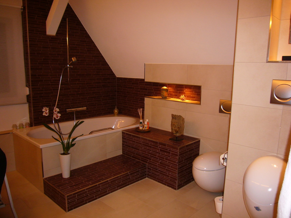 Esempio di una stanza da bagno contemporanea con vasca da incasso, WC sospeso, piastrelle marroni, piastrelle a mosaico, pareti bianche, pavimento con piastrelle in ceramica e pavimento beige