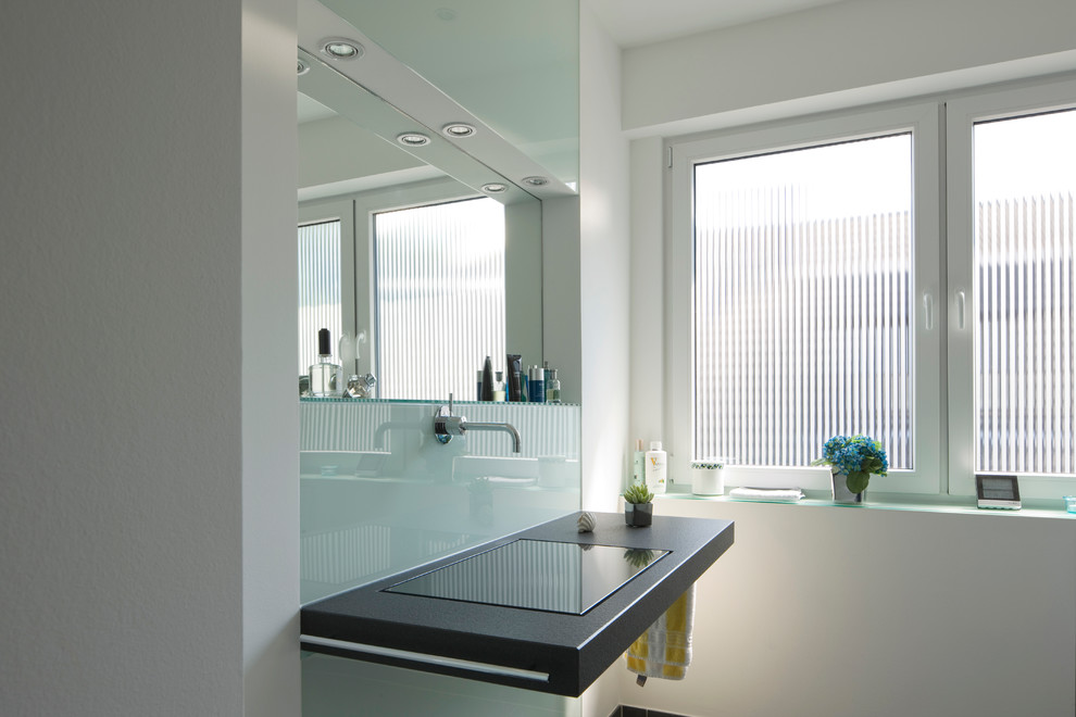Cette image montre une salle de bain design avec un mur blanc et un lavabo suspendu.