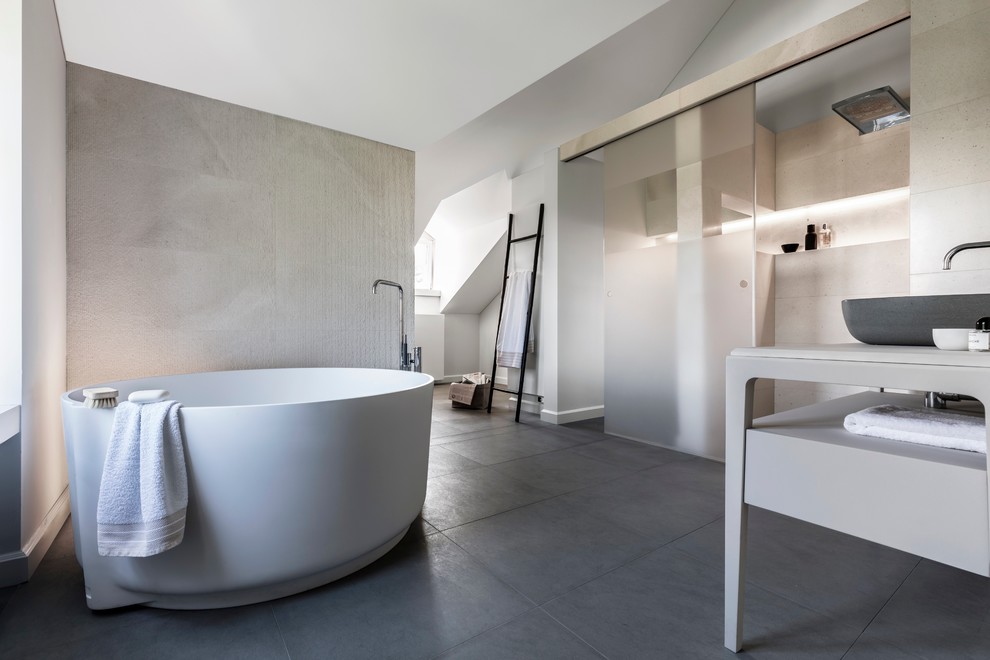 Diseño de cuarto de baño actual con armarios abiertos, puertas de armario grises, bañera japonesa, ducha empotrada, paredes grises y lavabo sobreencimera