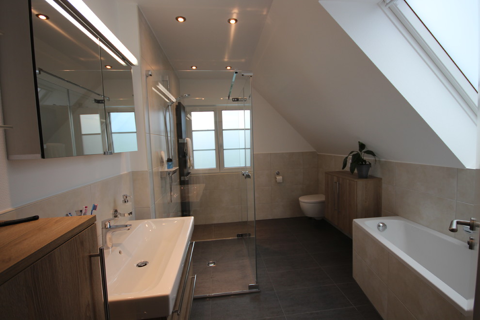 Пример оригинального дизайна: ванная комната среднего размера в современном стиле с угловой ванной, инсталляцией, серой плиткой, керамогранитной плиткой, серыми стенами, полом из керамогранита, душевой кабиной и раковиной с несколькими смесителями