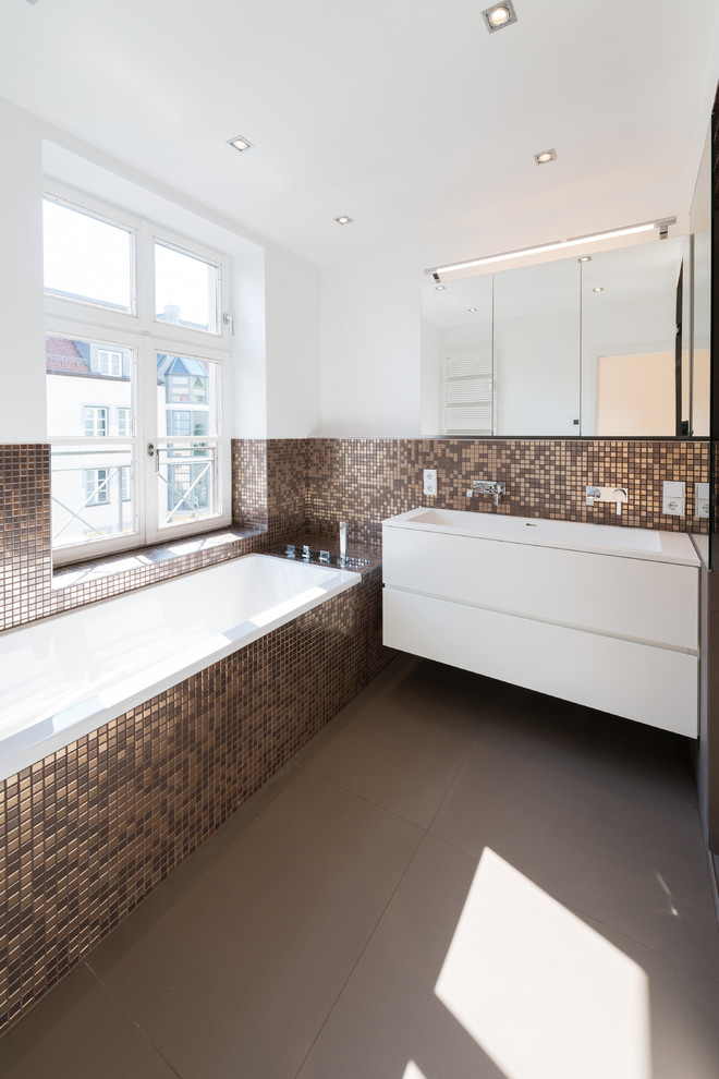 Свежая идея для дизайна: ванная комната среднего размера в современном стиле с монолитной раковиной, плоскими фасадами, белыми фасадами, накладной ванной, коричневой плиткой, плиткой мозаикой, белыми стенами и окном - отличное фото интерьера