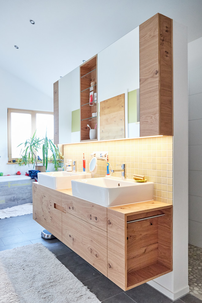 На фото: главная ванная комната в современном стиле с фасадами цвета дерева среднего тона с