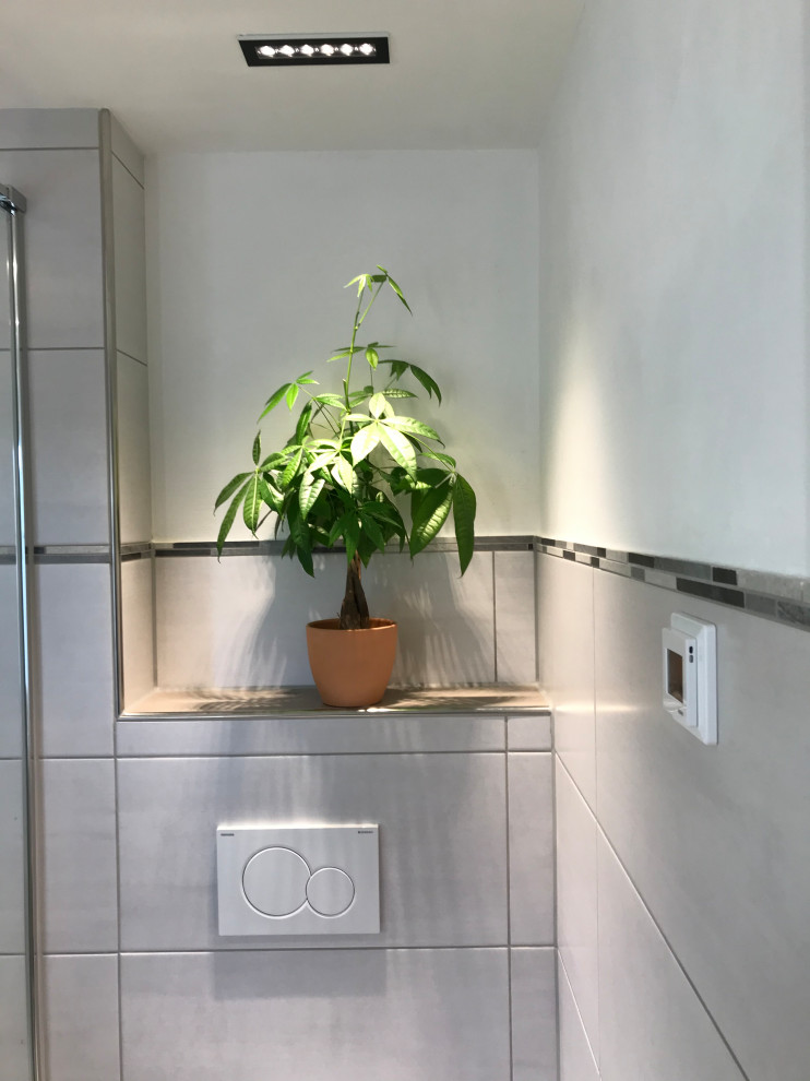 Idee per una piccola stanza da bagno con doccia design con WC a due pezzi, pareti bianche, pavimento con piastrelle effetto legno, pavimento marrone, soffitto ribassato e pannellatura