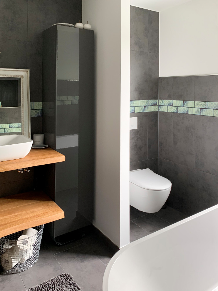 Foto på ett stort funkis brun badrum, med öppna hyllor, ett platsbyggt badkar, en öppen dusch, flerfärgad kakel, grå väggar, träbänkskiva, grått golv och med dusch som är öppen