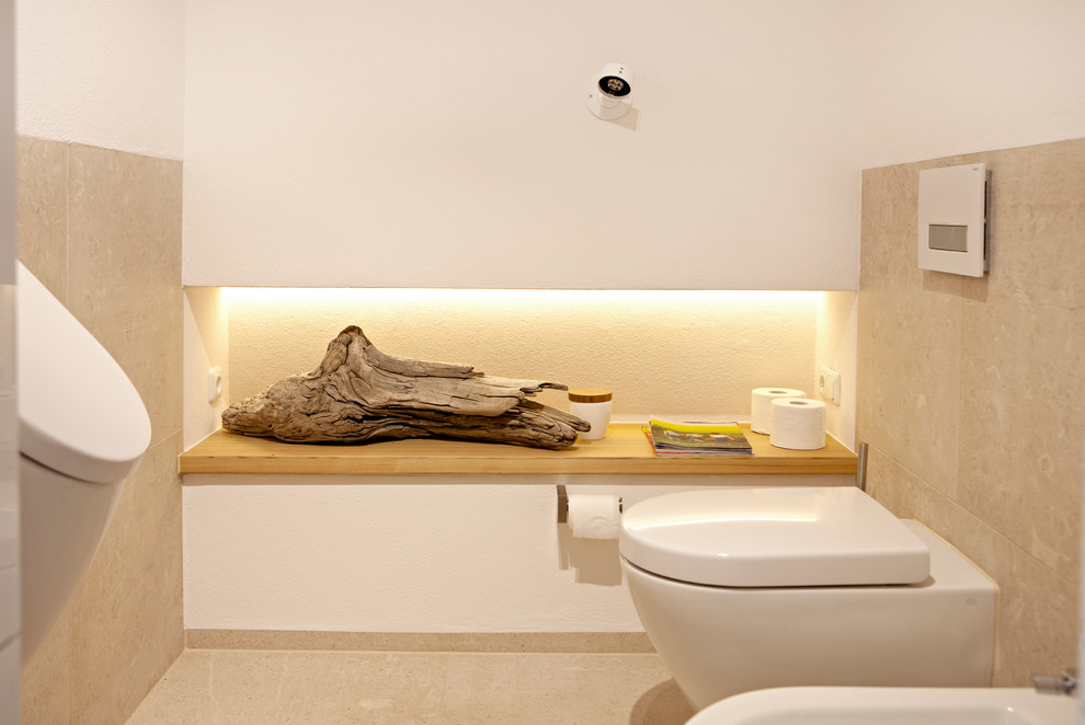 Imagen de cuarto de baño contemporáneo con armarios con paneles lisos, puertas de armario de madera clara, baldosas y/o azulejos marrones y aseo y ducha