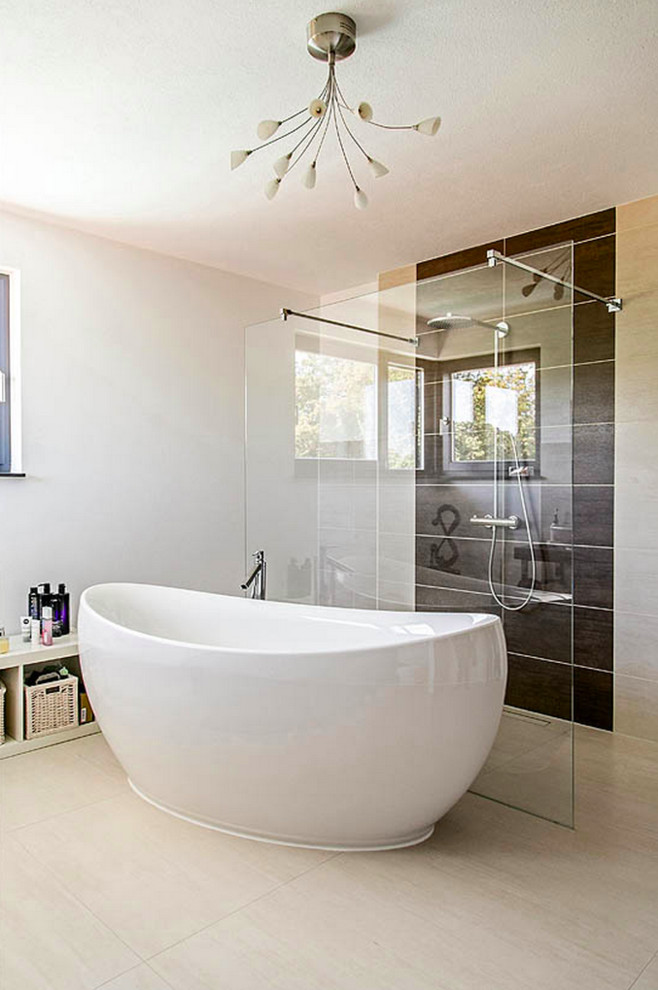 Modelo de cuarto de baño contemporáneo con bañera exenta, ducha abierta, baldosas y/o azulejos marrones, paredes blancas y suelo de madera clara