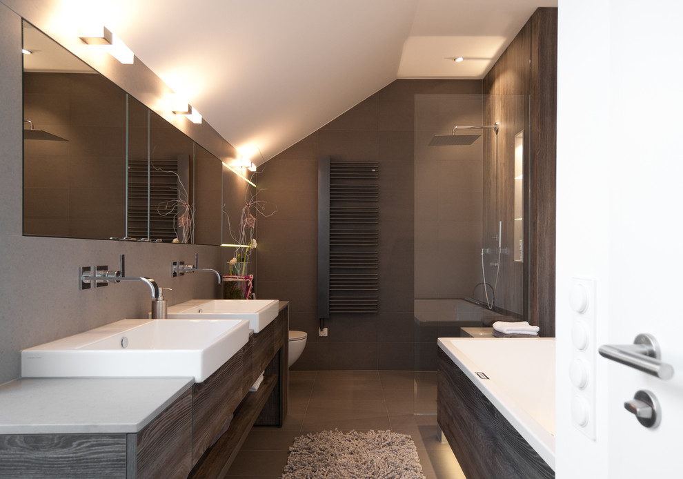 Photo of a large contemporary ensuite bathroom in Dusseldorf with a vessel sink, a built-in shower, brown tiles, brown walls, flat-panel cabinets, dark wood cabinets and a built-in bath.