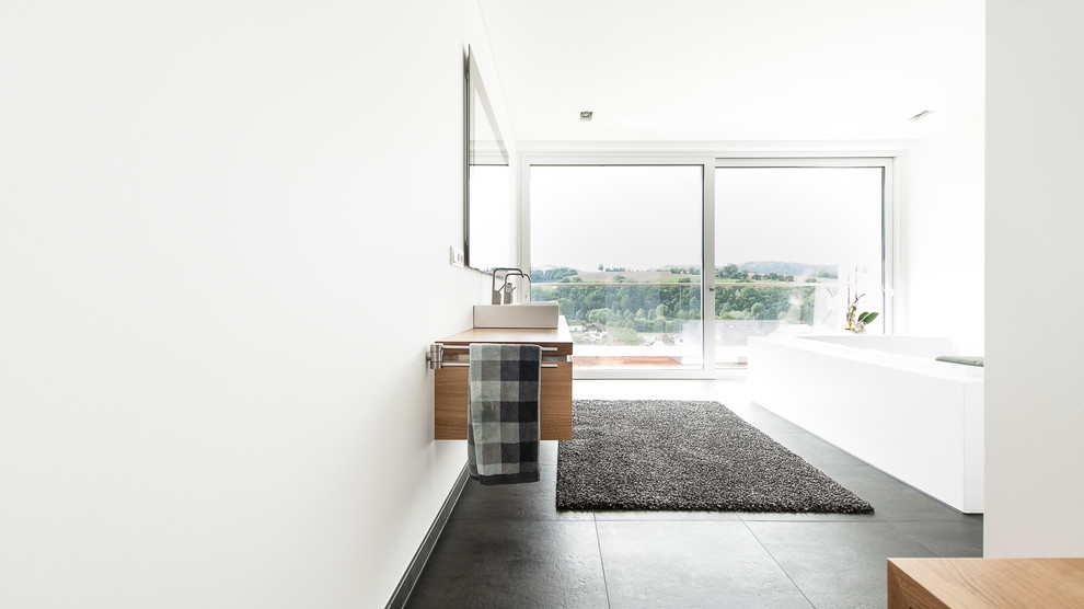 Großes Modernes Badezimmer mit hellbraunen Holzschränken, schwarzen Fliesen, weißer Wandfarbe, Aufsatzwaschbecken und Waschtisch aus Holz in Frankfurt am Main