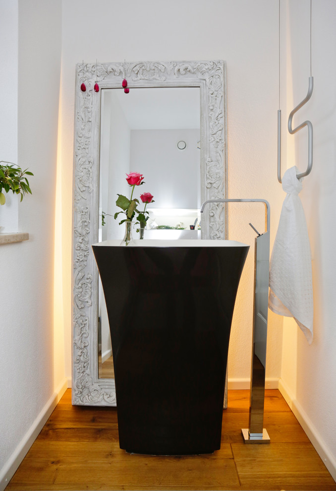 Ispirazione per una stanza da bagno contemporanea con ante nere, pareti bianche, pavimento in legno massello medio e pavimento marrone