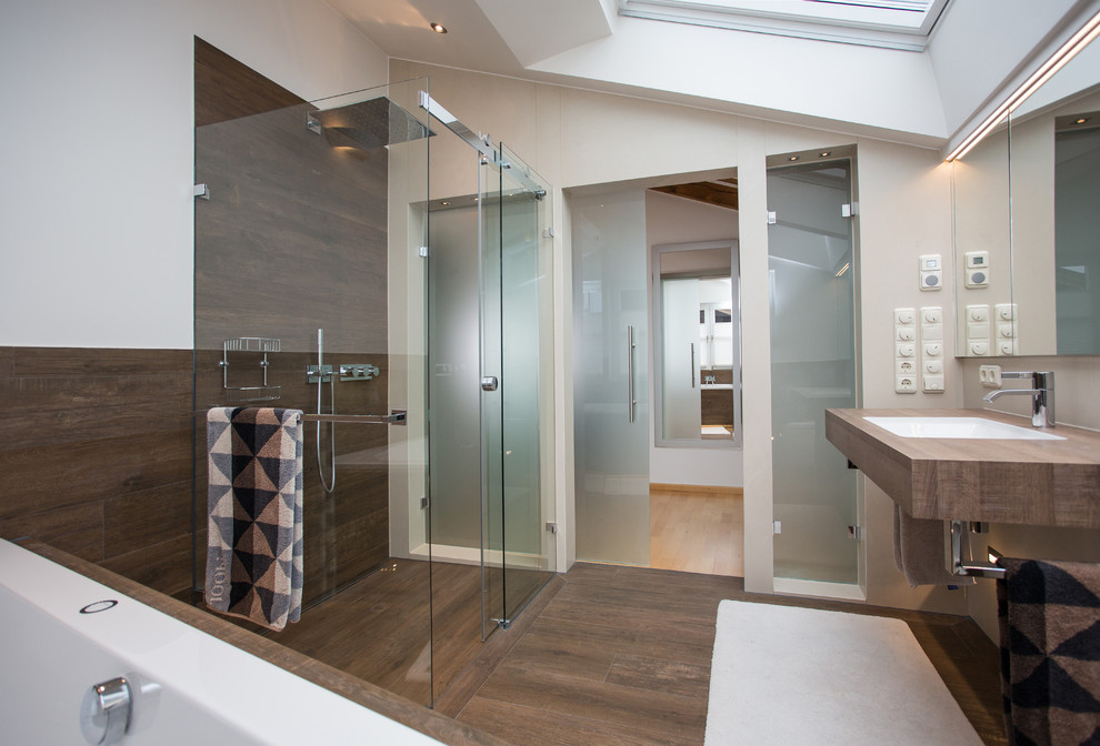 Esempio di una stanza da bagno minimal di medie dimensioni con vasca sottopiano, pareti bianche, lavabo da incasso e top in legno