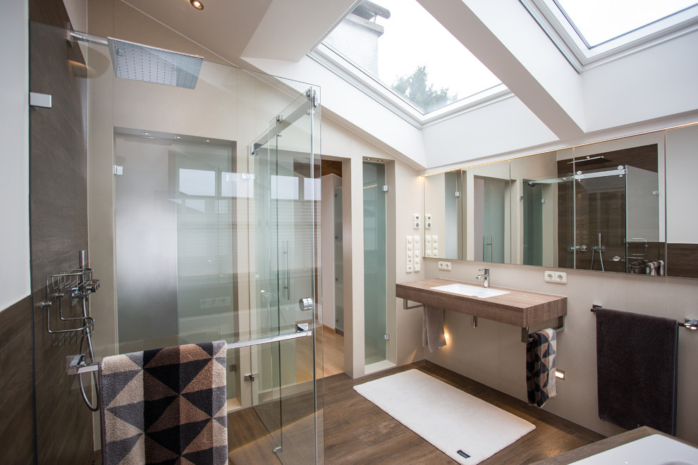 Idee per una stanza da bagno contemporanea di medie dimensioni con vasca sottopiano, pareti bianche, pavimento in legno massello medio, lavabo da incasso e top in legno