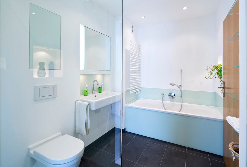 Inspiration for a large contemporary ensuite bathroom in Hamburg with flat-panel cabinets, white cabinets, a built-in bath, a walk-in shower, a two-piece toilet, green tiles, glass sheet walls, white walls, marble flooring, a vessel sink and granite worktops.