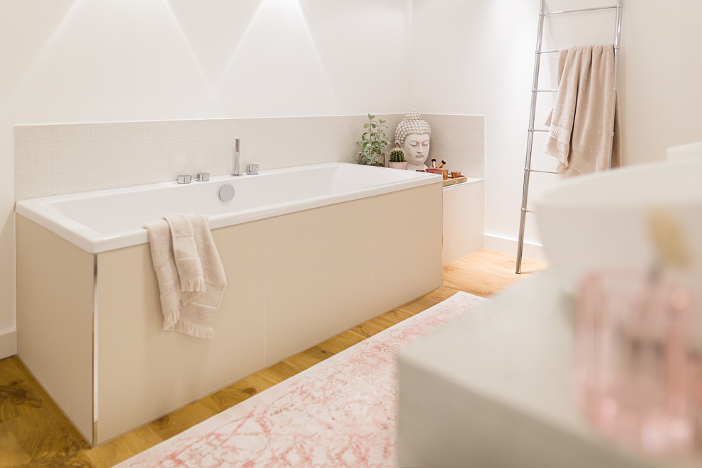 Inspiration for an expansive contemporary ensuite bathroom in Cologne with flat-panel cabinets, beige cabinets, a built-in bath, a built-in shower, a wall mounted toilet, beige tiles, mosaic tiles, white walls, medium hardwood flooring, a vessel sink, solid surface worktops, brown floors and beige worktops.