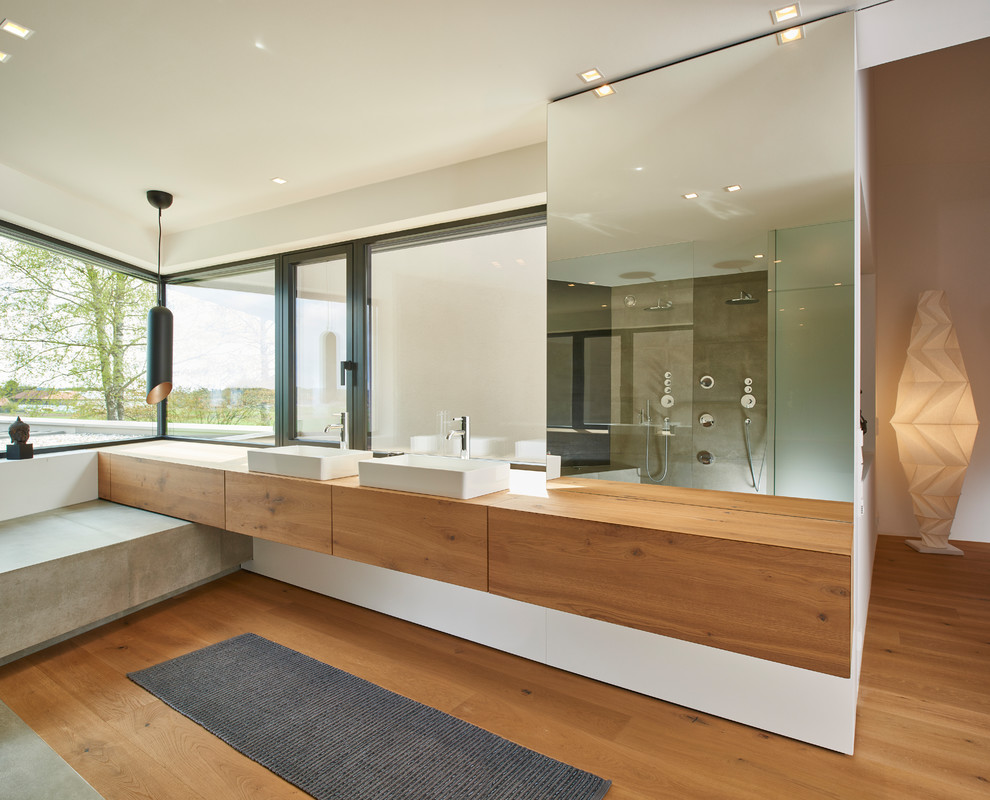 Großes Modernes Badezimmer mit flächenbündigen Schrankfronten, hellbraunen Holzschränken, brauner Wandfarbe, braunem Holzboden, Aufsatzwaschbecken, Waschtisch aus Holz, braunem Boden und brauner Waschtischplatte in Stuttgart