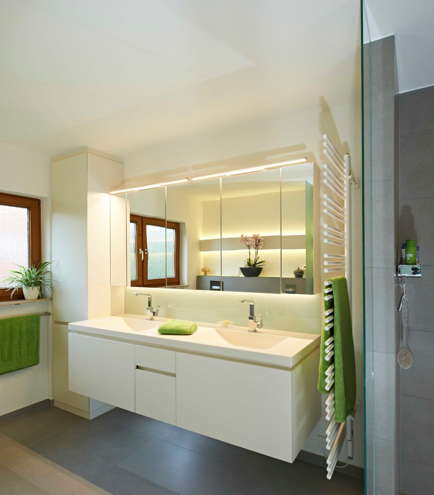 Свежая идея для дизайна: ванная комната среднего размера в современном стиле с плоскими фасадами, белыми фасадами, открытым душем, серой плиткой, белыми стенами, душевой кабиной, монолитной раковиной, серым полом, открытым душем и белой столешницей - отличное фото интерьера