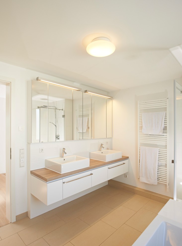 Idéer för att renovera ett mellanstort skandinaviskt beige beige badrum, med släta luckor, vita skåp, vita väggar, ett fristående handfat, träbänkskiva och beiget golv