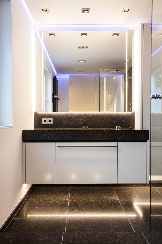 Стильный дизайн: ванная комната в современном стиле с врезной раковиной, белыми фасадами, душем без бортиков, плоскими фасадами, белыми стенами и зеркалом с подсветкой - последний тренд