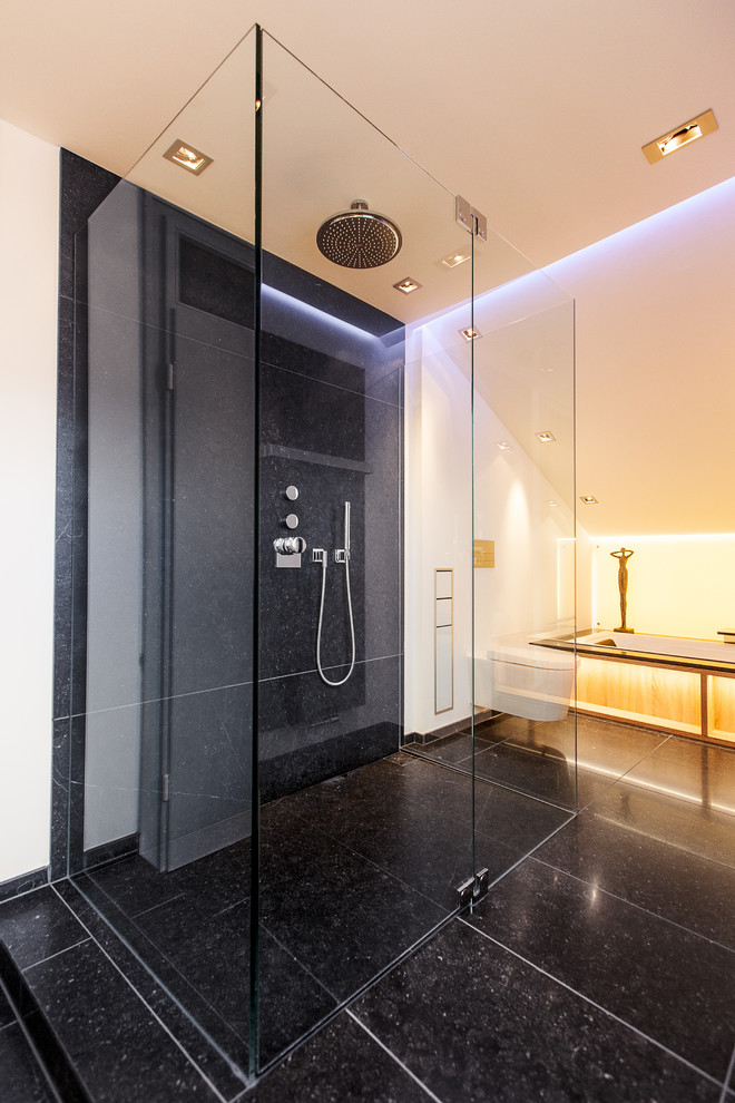 Идея дизайна: большая ванная комната в современном стиле с ванной в нише, душем без бортиков, инсталляцией, черной плиткой и белыми стенами