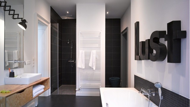 Esempio di una stanza da bagno con doccia moderna di medie dimensioni con vasca da incasso, doccia a filo pavimento, piastrelle nere, piastrelle in ceramica, top in legno, un lavabo e mobile bagno sospeso