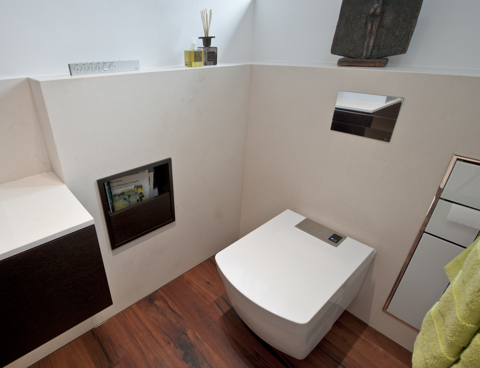 Cette image montre une salle de bain design avec un sol en bois brun.
