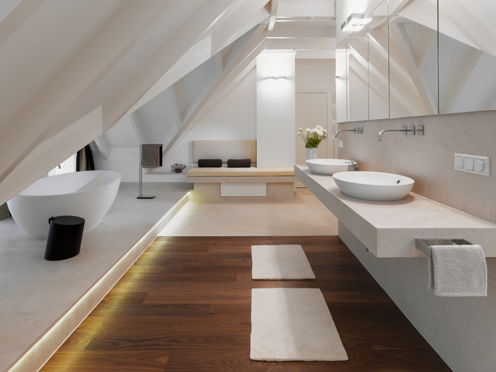 На фото: большая главная ванная комната в современном стиле с отдельно стоящей ванной, белыми стенами, настольной раковиной, мраморной столешницей, коричневым полом и бежевой столешницей