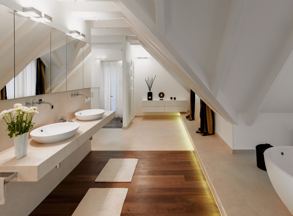 Idée de décoration pour une grande salle de bain principale asiatique avec un placard à porte plane, des portes de placard blanches, une baignoire indépendante, un mur blanc, une vasque, un plan de toilette en marbre, un sol marron et un plan de toilette beige.